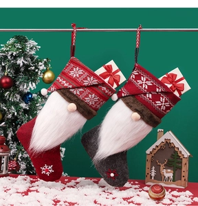 Detail of red and grey gnome Christmas stockings with plush beard and mini gift boxes
