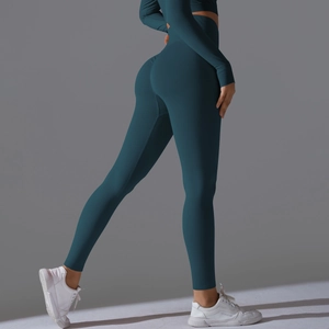 Detail view of high waisted dark teal yoga leggings with seamless texture and lifting effect