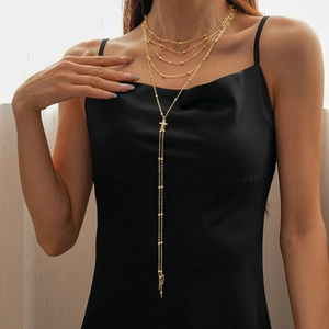 Elegant gold multi-layer chain necklace featuring a cross pendant on a model
