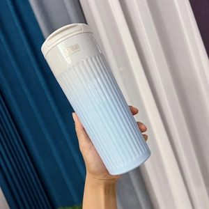 Detail of blue gradient stainless steel coffee mug with non-slip vertical texture