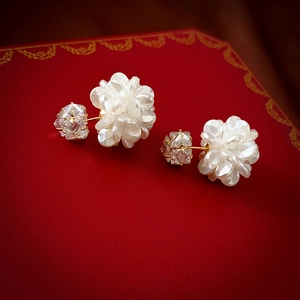 Detail of sweet acrylic flower earrings with square zircon crystals on red gift box