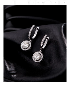 Macro shot of S925 sterling silver halo lever-back earrings with sparkling zircons
