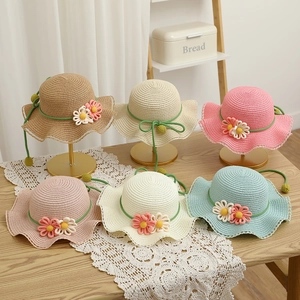 Detail of colorful children straw hats with floral decor and delicate lace brim edges
