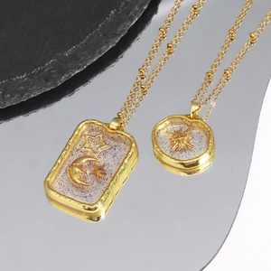 Detailed shot of gold celestial necklaces with purple glitter star and moon pendants