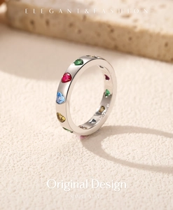 Macro side view of silver ring with colorful heart-shaped rhinestones on textured base