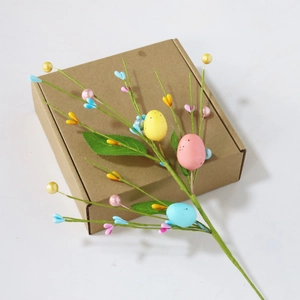 Easter decorative branch with colorful speckled eggs, artificial berries and green leaves