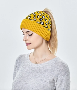 Détail du bonnet en tricot léopard jaune montrant l'ouverture pratique pour queue de cheval