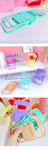 Macro detail of foldable mini chair phone stand in pastel purple plastic material