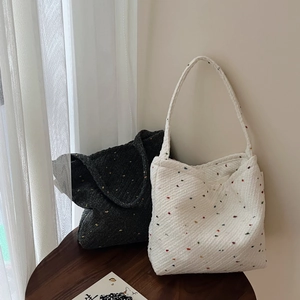 Vista dettagliata di borse tote intrecciate con pois colorati in bianco e nero