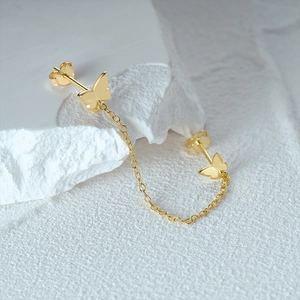 Detailed macro view of S925 sterling silver gold butterfly chain link earrings
