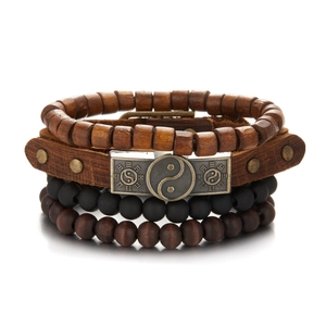 Detail of multi-layer leather bracelet set with wooden beads and Tai Chi metal charm
