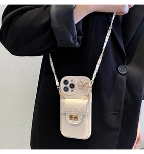 Close-up of cream leather phone case with quilted card holder and gold butterfly clasp detail