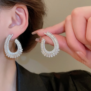 Macro detail of silver drop earrings featuring pavé-set rectangular cubic zirconia stones