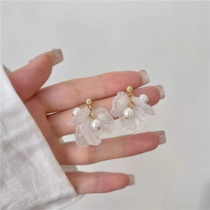 Detailed view of floral pearl earrings with frosted petals and gold metal accents