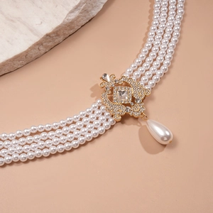 Detail of baroque multilayer pearl necklace with a gold rhinestone centerpiece and drop pendant
