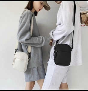 Detail view of nylon crossbody bags in black and white with adjustable shoulder straps