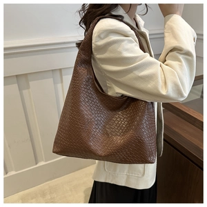 Sac fourre-tout tressé marron porté épaule avec blazer crème et grande capacité