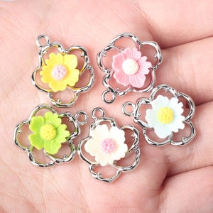 Colorful hollow flower charms with resin center for DIY jewelry making held in hand