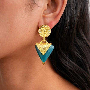Gros plan de boucles d'oreilles triangulaires rétro en résine avec strass et base dorée