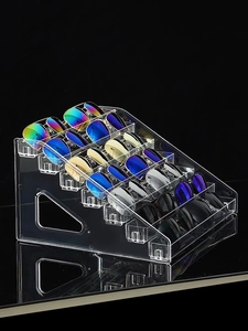 Macro shot of 6-tier clear acrylic tiered sunglasses display stand on reflective surface