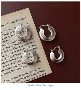 Detail view of matte S925 sterling silver hoop earrings showing brushed texture and S925 stamp