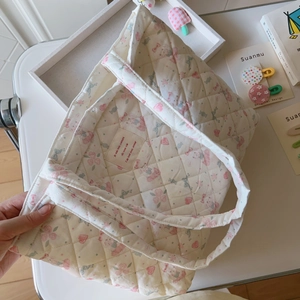 Detailaufnahme der gesteppten Tragetasche mit Blumenmuster, Hasen und Stoffetikett