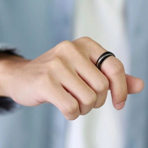 Detailed close-up of a men's black and silver two-tone stainless steel ring on model's hand