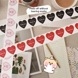 Macro view of heart-shaped Thank You stickers on notebook for gift packaging decor