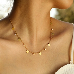 Primo piano della collana a farfalla dorata con zirconi indossata da una modella