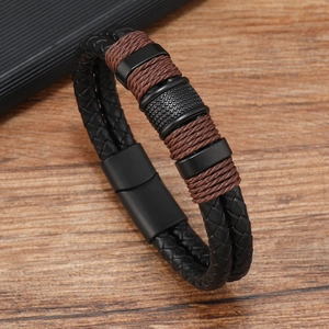 Detail of multi-layer braided leather bracelet with magnetic clasp on wood surface