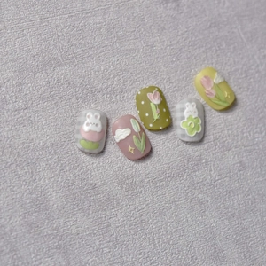 Macro detail of 3D embossed rabbit and tulip patterns on multi-colored Japanese press-on nails
