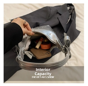 Détails de l'intérieur du sac argenté montrant l'espace pour téléphone et maquillage