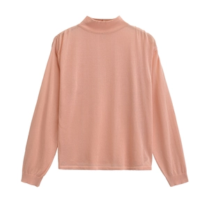 Détail d'un pull en maille rose clair à col montant avec des finitions de manches nettes