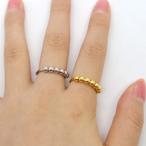 Detalle de las cuentas giratorias en anillos antiestrés de acero plata y oro