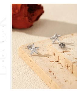 Detailed shot of S925 sterling silver starfish earrings with white pearls on stone