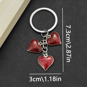 Detail showing red glitter heart keychains with dimensions 7.3cm length and 3cm width