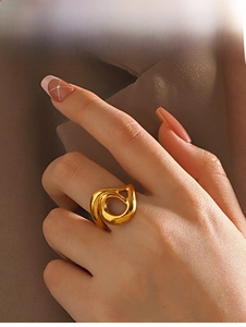 Macro detail of a hollow irregular gold geometric ring with a polished metallic finish