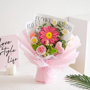 Close-up of handmade crocheted flower bouquet with pink daisy and white rose details