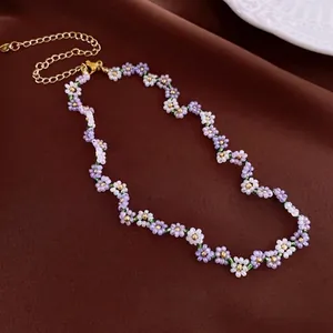 Floral beaded necklace with purple and white handmade flowers and golden clasp