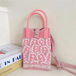 Detail of pink knitted crossbody bag with Becoming Rich text and magnetic snap closure