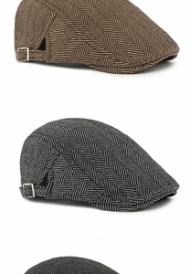 Close-up of herringbone newsboy caps with adjustable side metal buckles in brown and grey