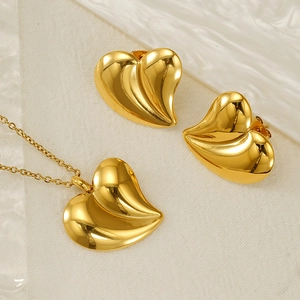 Polished gold heart jewelry set with necklace and earrings on white background
