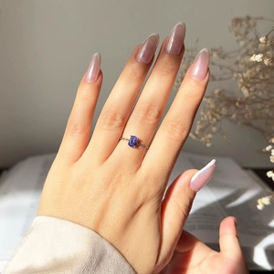 Detailed view of women gold-plated chain ring featuring an oval purple zircon gemstone