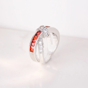 Macro shot of silver criss-cross ring with inlaid red gemstone and white cubic zirconia
