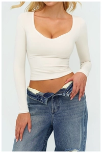 Dettaglio del crop top a maniche lunghe con scollo a U in tessuto strutturato bianco crema