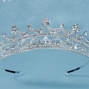 Macro view of bridal tiara featuring symmetrical rhinestone patterns and center diamond