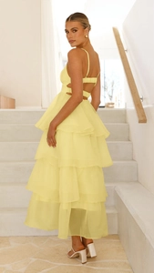 Detail of light yellow tiered cake dress with backless design and chiffon layers