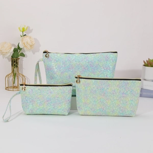 Three-piece set of light green iridescent lace makeup bags in varying sizes for travel