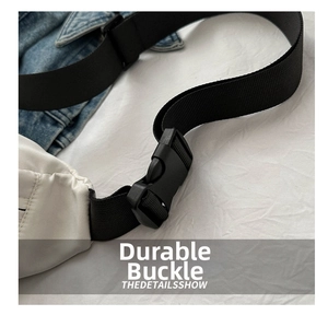 Close-up of durable black plastic buckle on a white oxford fabric crossbody bag