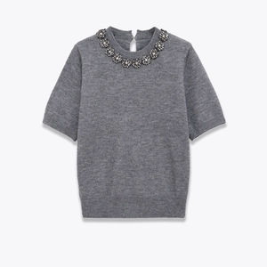Close-up of crystal flower embellishments on grey round neck short sleeve knit top